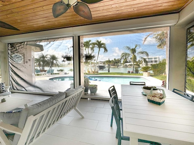 sunroom with wood ceiling and a water view