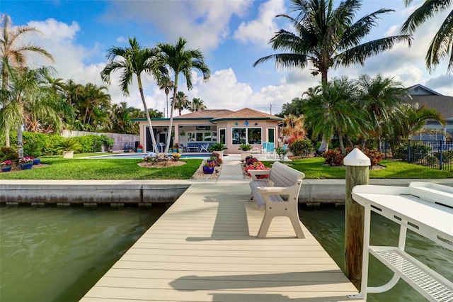 view of dock featuring a water view, a yard, a swimming pool, and a patio area