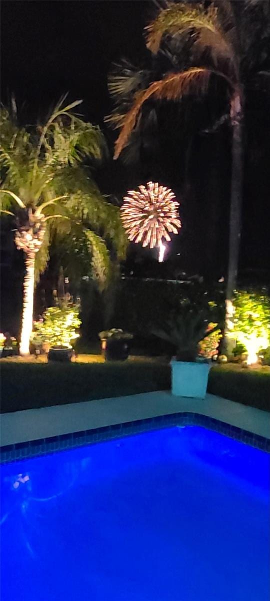 view of pool at twilight