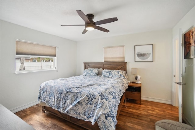 bedroom with dark hardwood / wood-style flooring and ceiling fan