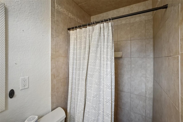 bathroom with a shower with curtain and toilet