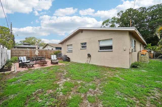 rear view of property with central AC unit, a yard, and a patio area