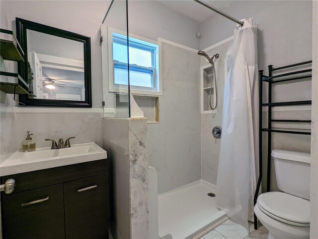 bathroom featuring walk in shower, ceiling fan, vanity, and toilet