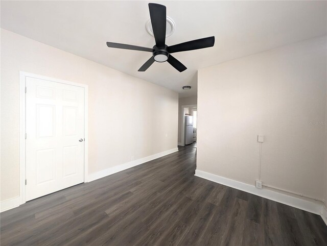 unfurnished room featuring ceiling fan, baseboards, and dark wood-style floors