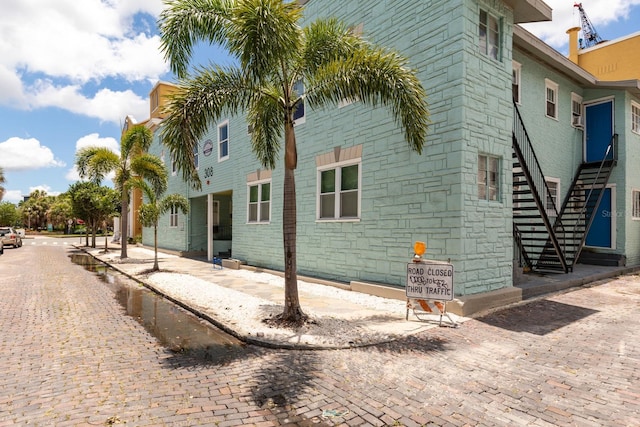 view of property exterior with stairs and stone siding