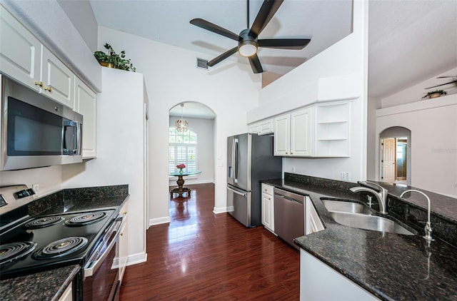 kitchen featuring arched walkways, dark wood-style flooring, a sink, appliances with stainless steel finishes, and open shelves