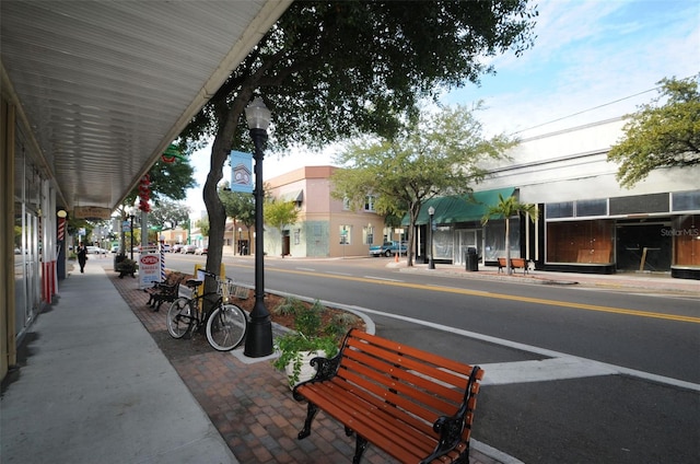 view of road featuring street lights, curbs, and sidewalks