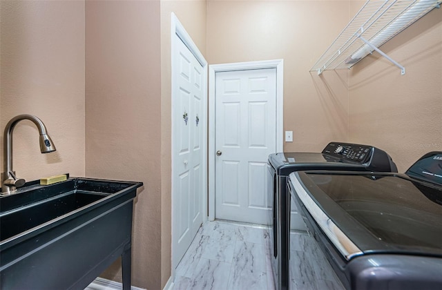 laundry room with marble finish floor, laundry area, a sink, and washing machine and clothes dryer