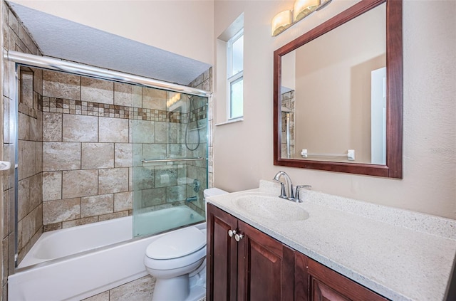 bathroom with toilet, enclosed tub / shower combo, and vanity