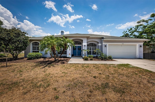 ranch-style home with driveway, a garage, a front lawn, and stucco siding