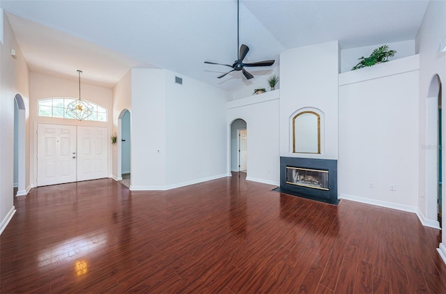 unfurnished living room with a fireplace with flush hearth, visible vents, arched walkways, and wood finished floors