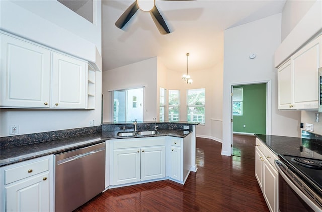 kitchen with lofted ceiling, a peninsula, a sink, white cabinetry, and stainless steel dishwasher