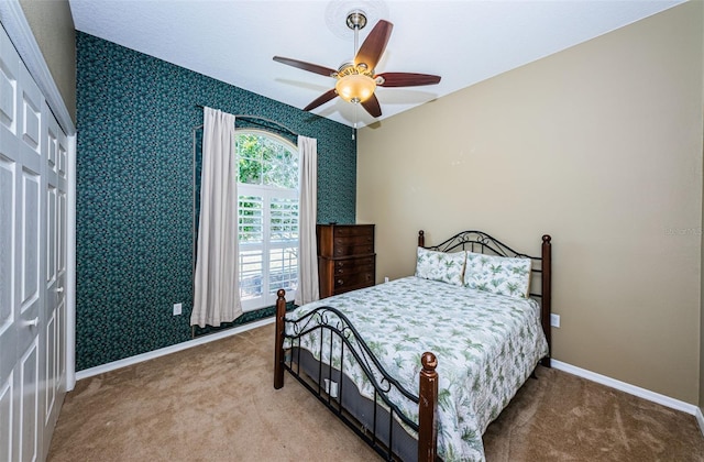 carpeted bedroom with ceiling fan, baseboards, and wallpapered walls