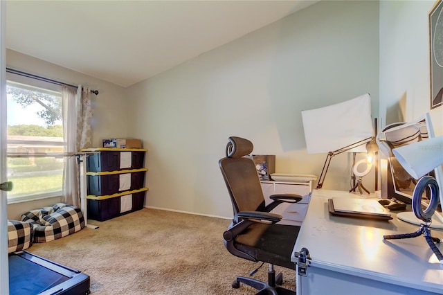 carpeted home office with vaulted ceiling