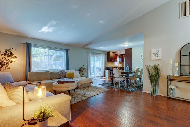 living room featuring dark hardwood / wood-style flooring and vaulted ceiling