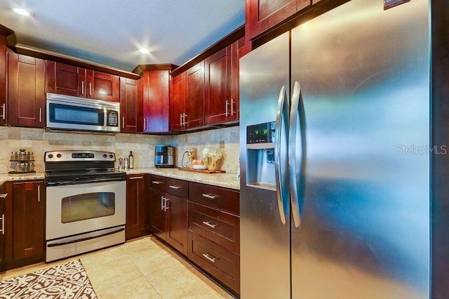 kitchen with tasteful backsplash, light stone counters, and stainless steel appliances