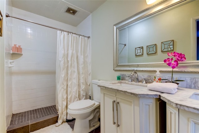 bathroom with tile patterned flooring, vanity, toilet, and walk in shower