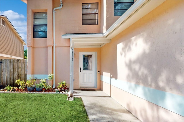 doorway to property featuring a lawn