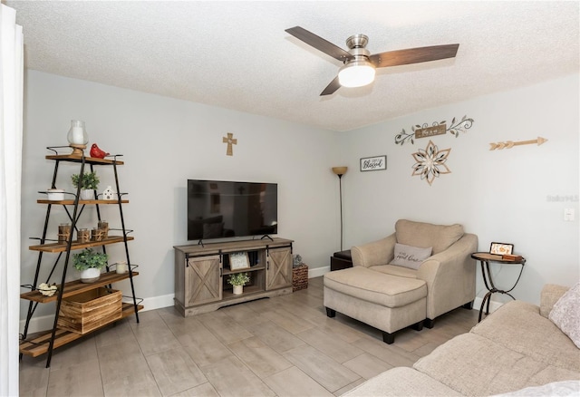 living room with ceiling fan and a textured ceiling