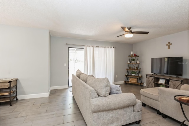 living room featuring ceiling fan and a textured ceiling