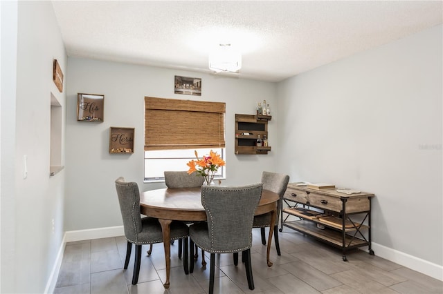 dining area with hardwood / wood-style floors and a textured ceiling