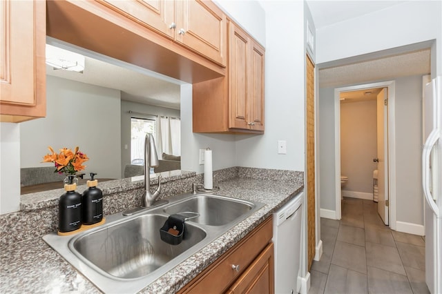 kitchen featuring white appliances, sink, and light tile patterned floors