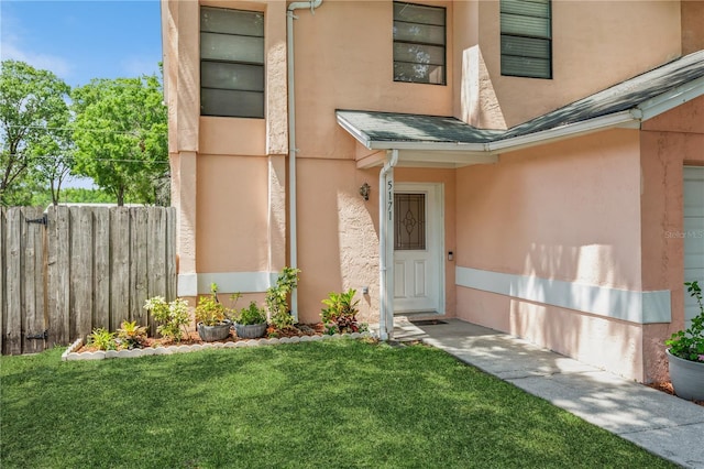 doorway to property with a lawn