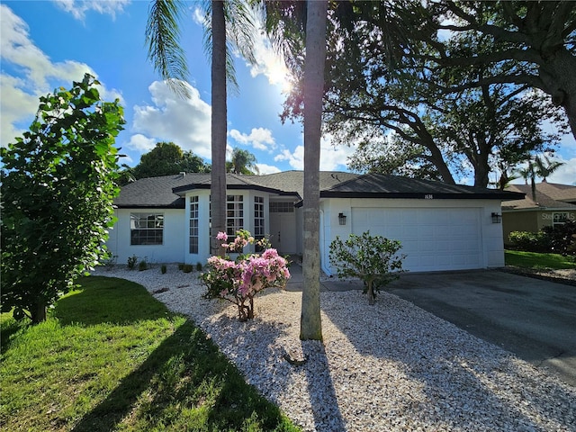 single story home featuring a front lawn and a garage