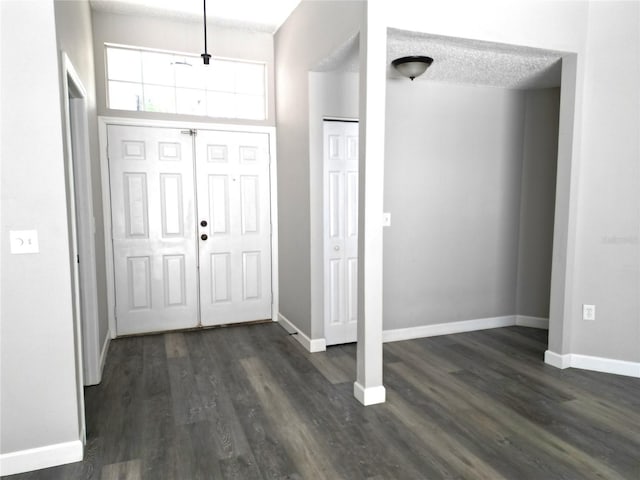 entryway featuring a textured ceiling and dark wood-type flooring