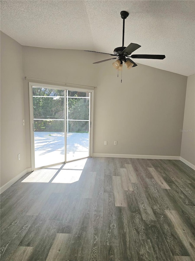 spare room with a textured ceiling, ceiling fan, dark wood-type flooring, and vaulted ceiling