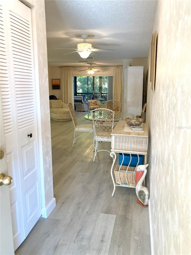 hall with hardwood / wood-style floors and a textured ceiling