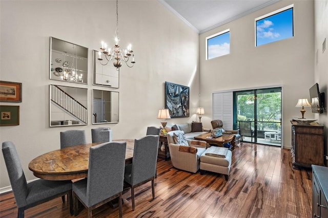 dining space with a notable chandelier, dark hardwood / wood-style flooring, ornamental molding, and a high ceiling