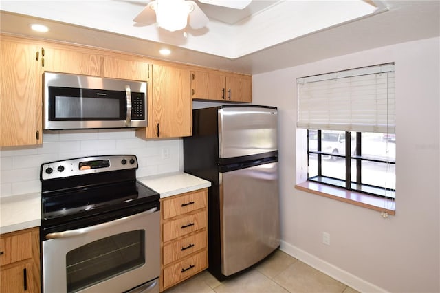 kitchen with ceiling fan, decorative backsplash, stainless steel appliances, light tile patterned floors, and light brown cabinetry