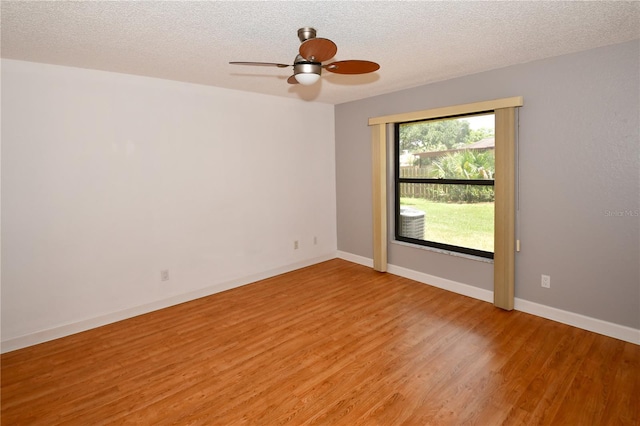 empty room featuring hardwood / wood-style flooring, a textured ceiling, and ceiling fan