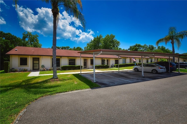 view of front of property featuring a front yard and a carport