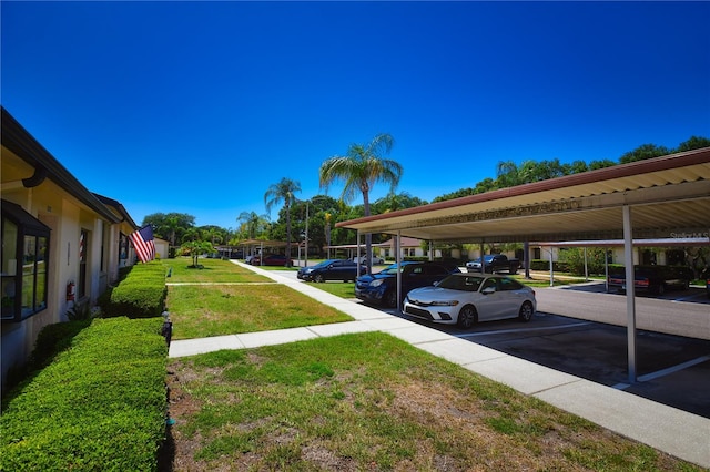 view of car parking featuring a lawn and a carport