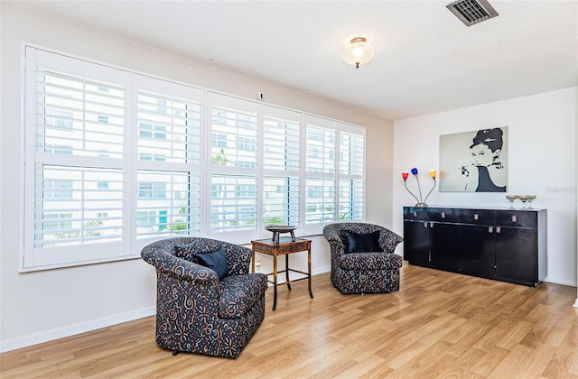 living area featuring hardwood / wood-style floors, a textured ceiling, and plenty of natural light