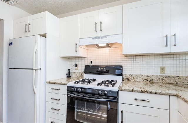 kitchen featuring tasteful backsplash, black gas range oven, a textured ceiling, white refrigerator, and white cabinetry