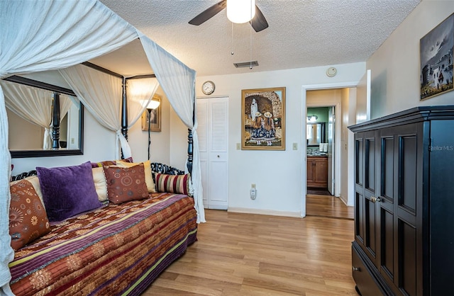 living room featuring a textured ceiling, light wood-type flooring, and ceiling fan