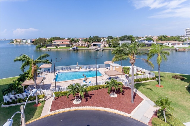 view of pool with a water view, a patio area, and a lawn