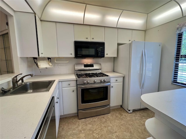 kitchen featuring dishwasher, gas range, freestanding refrigerator, black microwave, and a sink