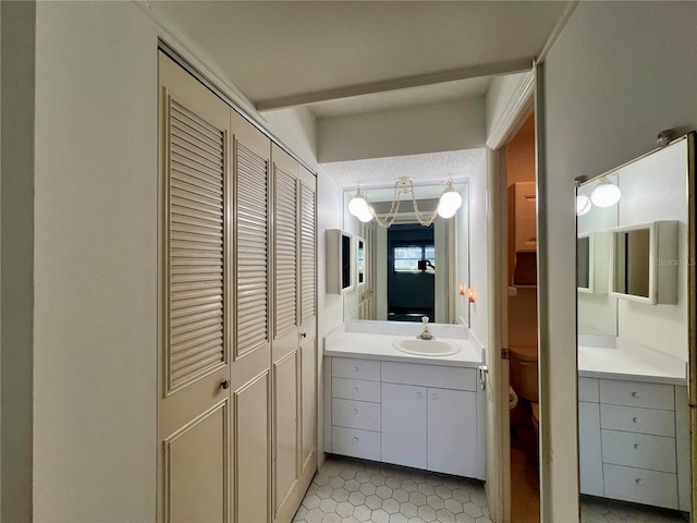 bathroom with tile flooring, vanity with extensive cabinet space, and a textured ceiling