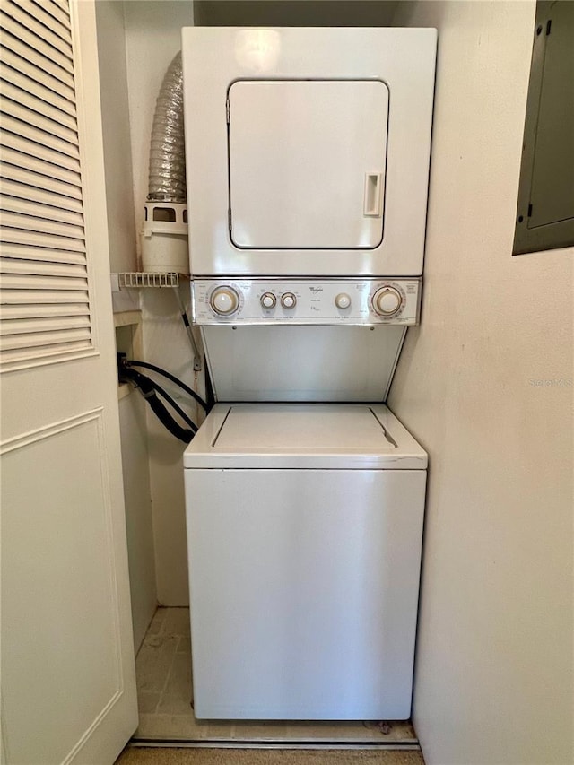 laundry room featuring laundry area, stacked washer and clothes dryer, and electric panel