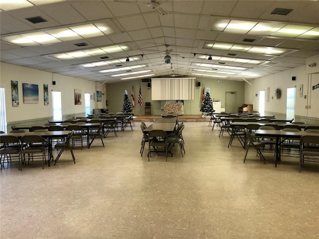 dining area with visible vents, a drop ceiling, and wainscoting