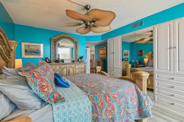 bedroom with ceiling fan and a textured ceiling