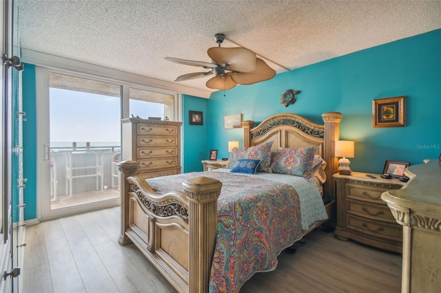 bedroom featuring ceiling fan, light wood-type flooring, and a textured ceiling