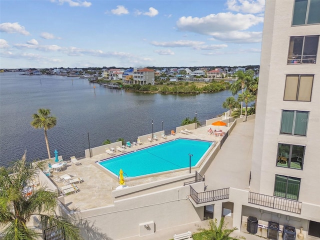 view of pool with a water view, central AC unit, and a patio area