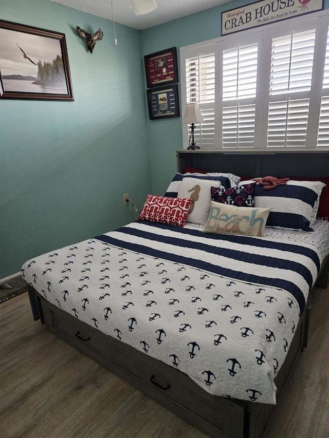 bedroom with hardwood / wood-style floors and a textured ceiling