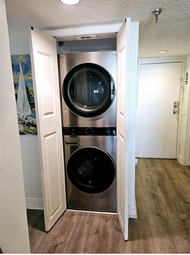6035 Sea Ranch Dr Unit 505, Hudson, FL 34667 - laundry area featuring estacked washer and dryer, wood finished floors, and a textured ceiling