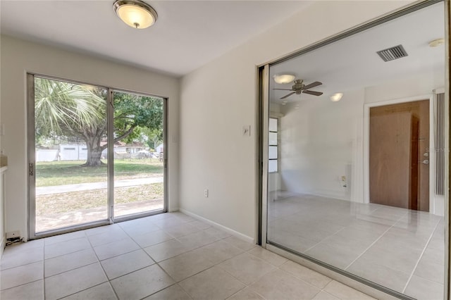 tiled spare room with plenty of natural light and ceiling fan